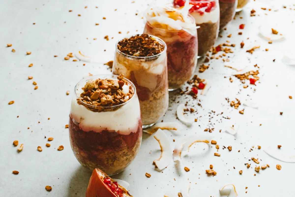 Amandes, noisettes et dés d'abricots secs pesés sur une balance de cuisine à côté d'une verrine vide