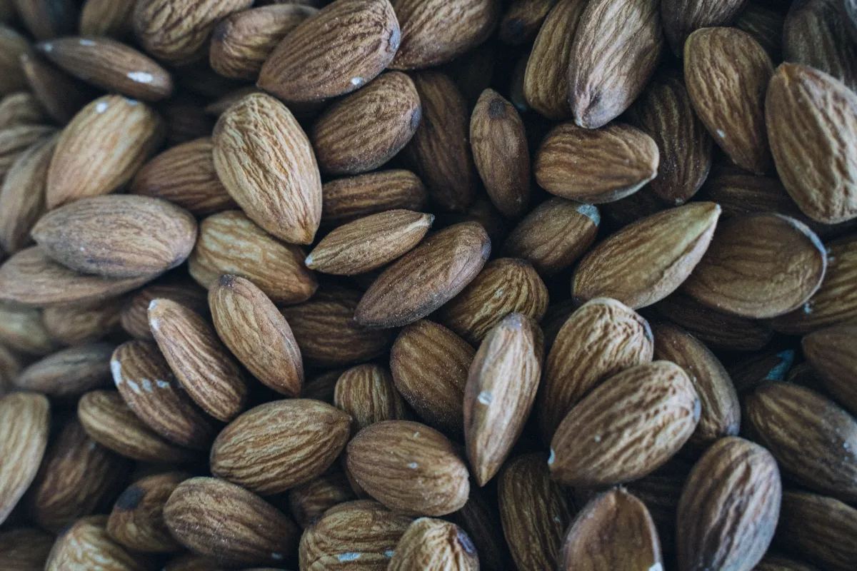 Amandes entières torréfiées sur une plaque de four, lumière chaude latérale